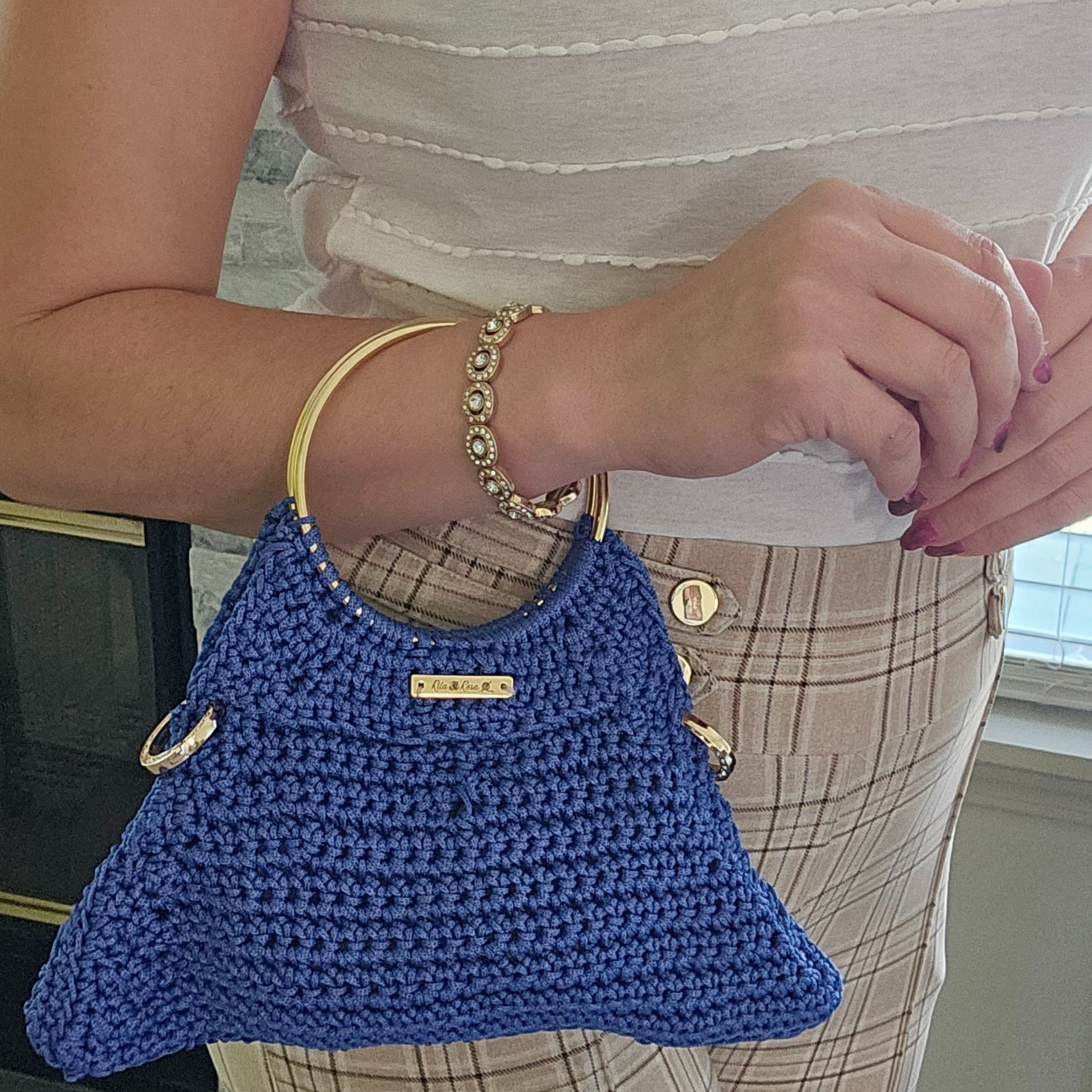 Model showcasing Denim Blue Arco Luxe Crochet Bag – handmade macramé crossbody bag with gold chain strap, loop ring grip handle, and secure magnetic closure, perfect for stylish everyday wear.