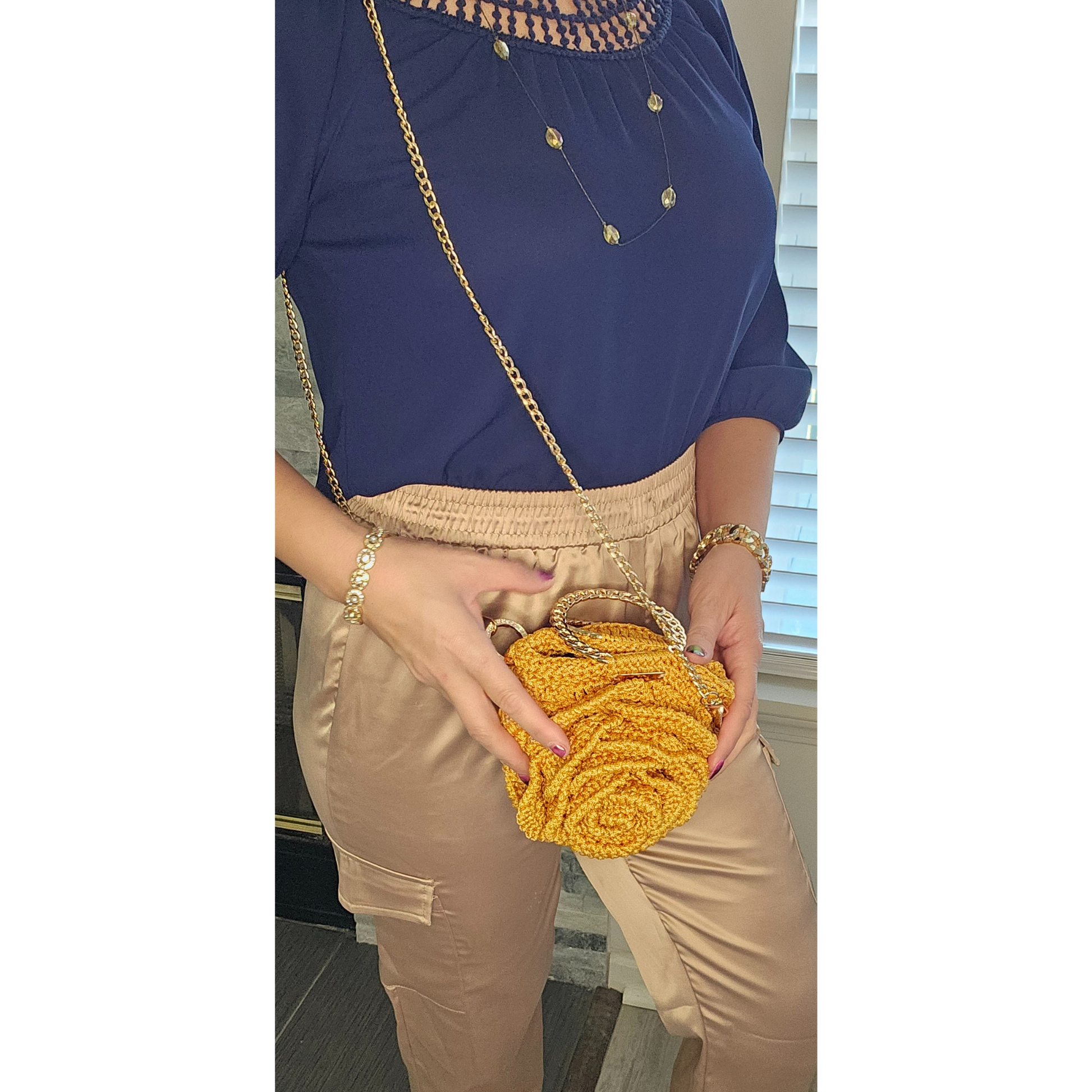 Model showcasing Gold Rosa Bloom Macramé Crossbody – handmade 3D rose design bag, lightweight macramé craftsmanship with gold chain strap, perfect for Mother's Day, weddings, and summer outfits.