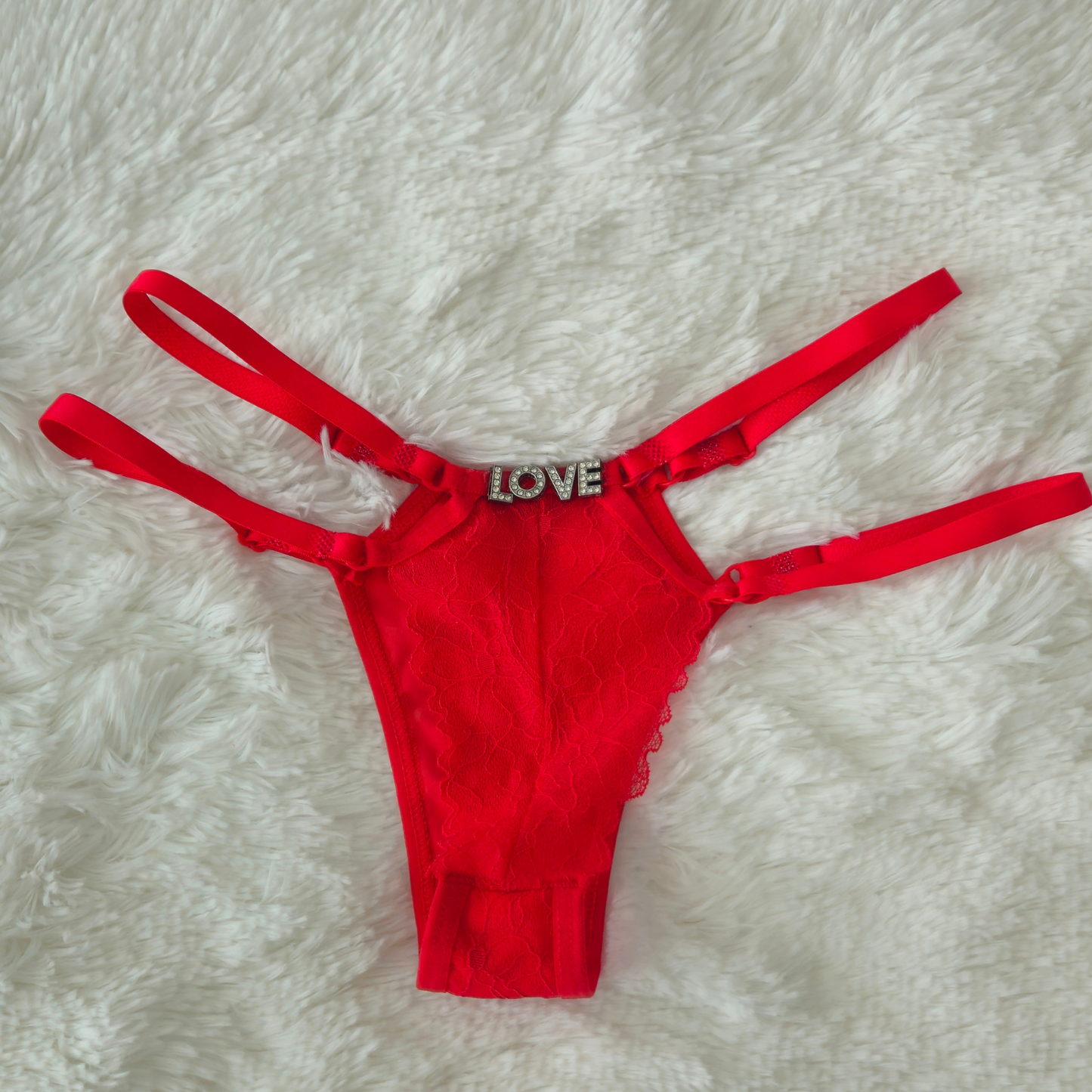 Limited edition red strappy lace G-string from the Brilho collection with LOVE crystal hardware and architectural double-strap design.