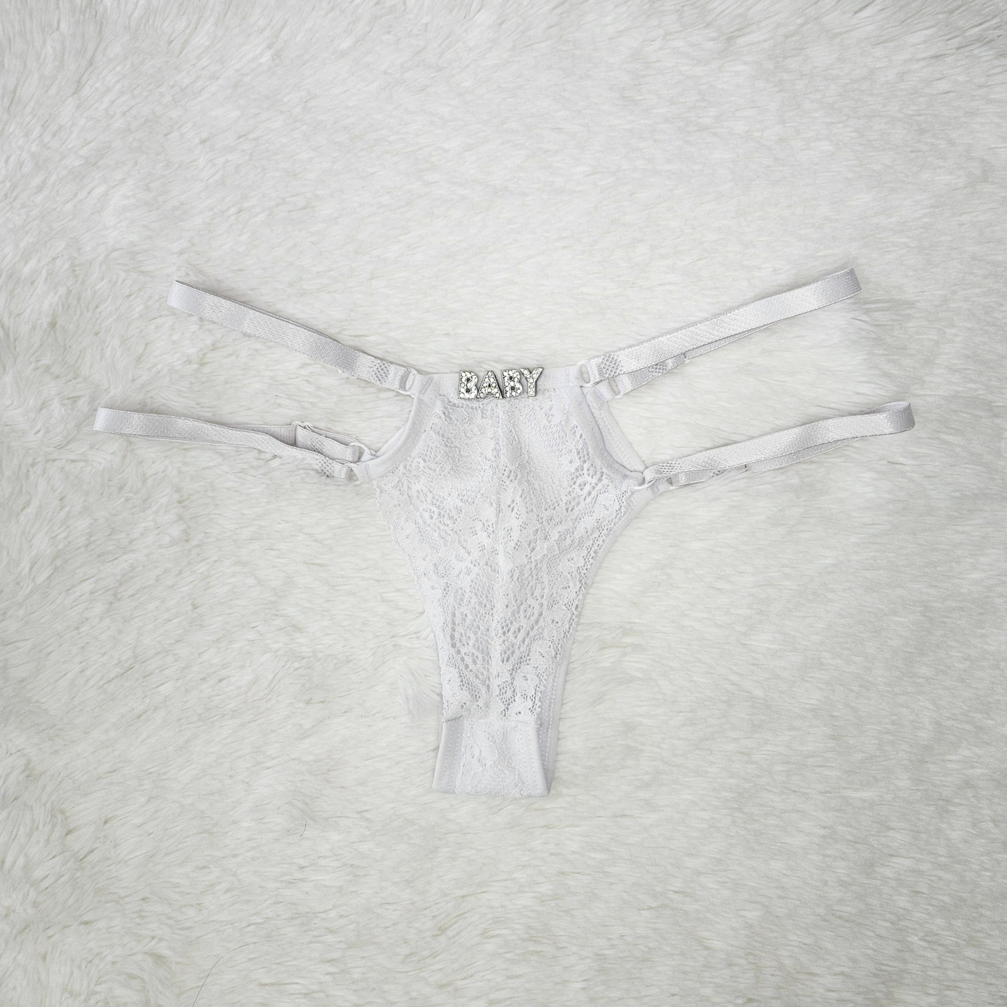 Brilho Adjustable Strappy Lace G-String in White featuring a hand-set BABY rhinestone statement and four satin adjustable straps.