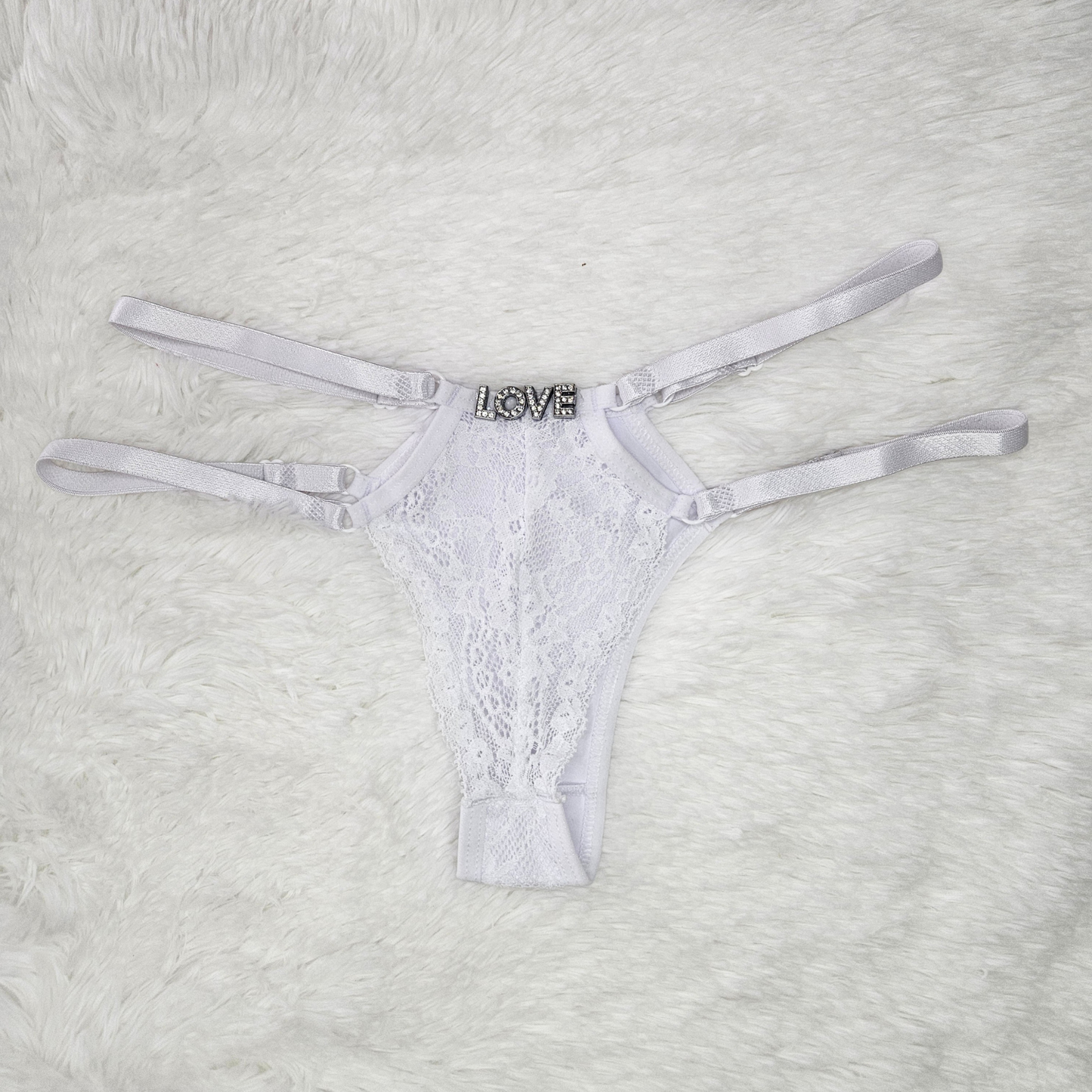 Brilho Adjustable Strappy Lace G-String in white featuring a hand-set LOVE rhinestone statement and four satin adjustable straps.