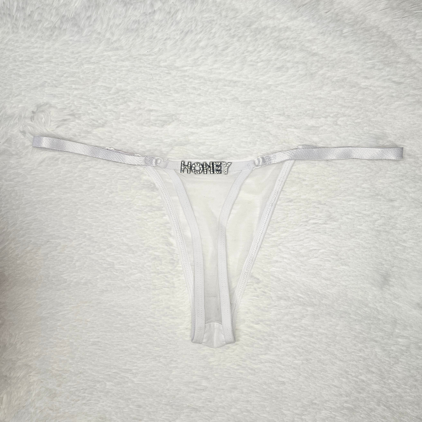 Hand-finished white Brazilian lace G-string with HONEY rhinestone statement charm.