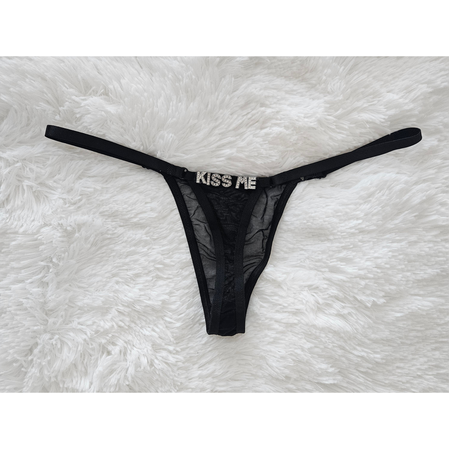 Rita Rosa black sheer mesh thong featuring KISS ME jewelry-grade crystal letters.