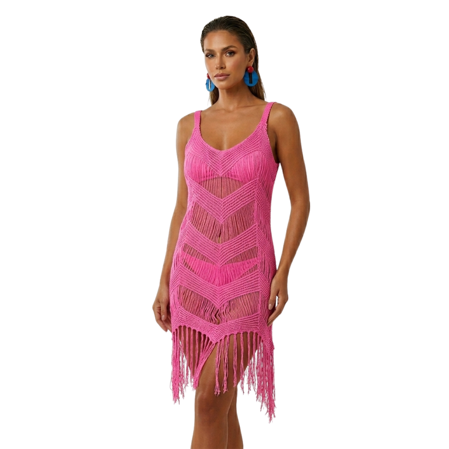 A model wearing the vibrant hot pink Rita Rosa chevron fringe cover-up dress with blue geometric earrings, featuring a bold see-through knit design on a clean white background.