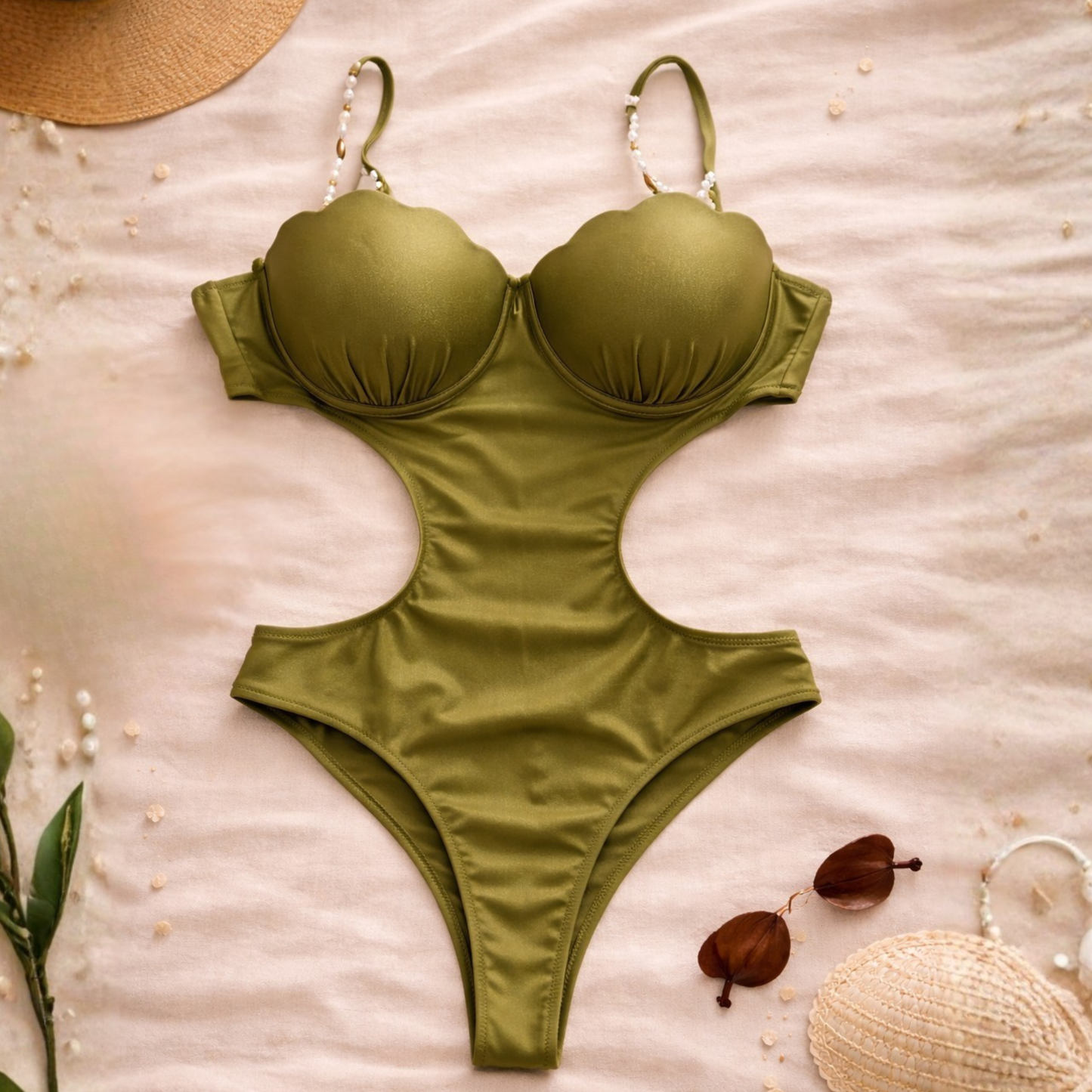 Green satin one-piece swimsuit with pearl straps and cut-out design, flat lay styling