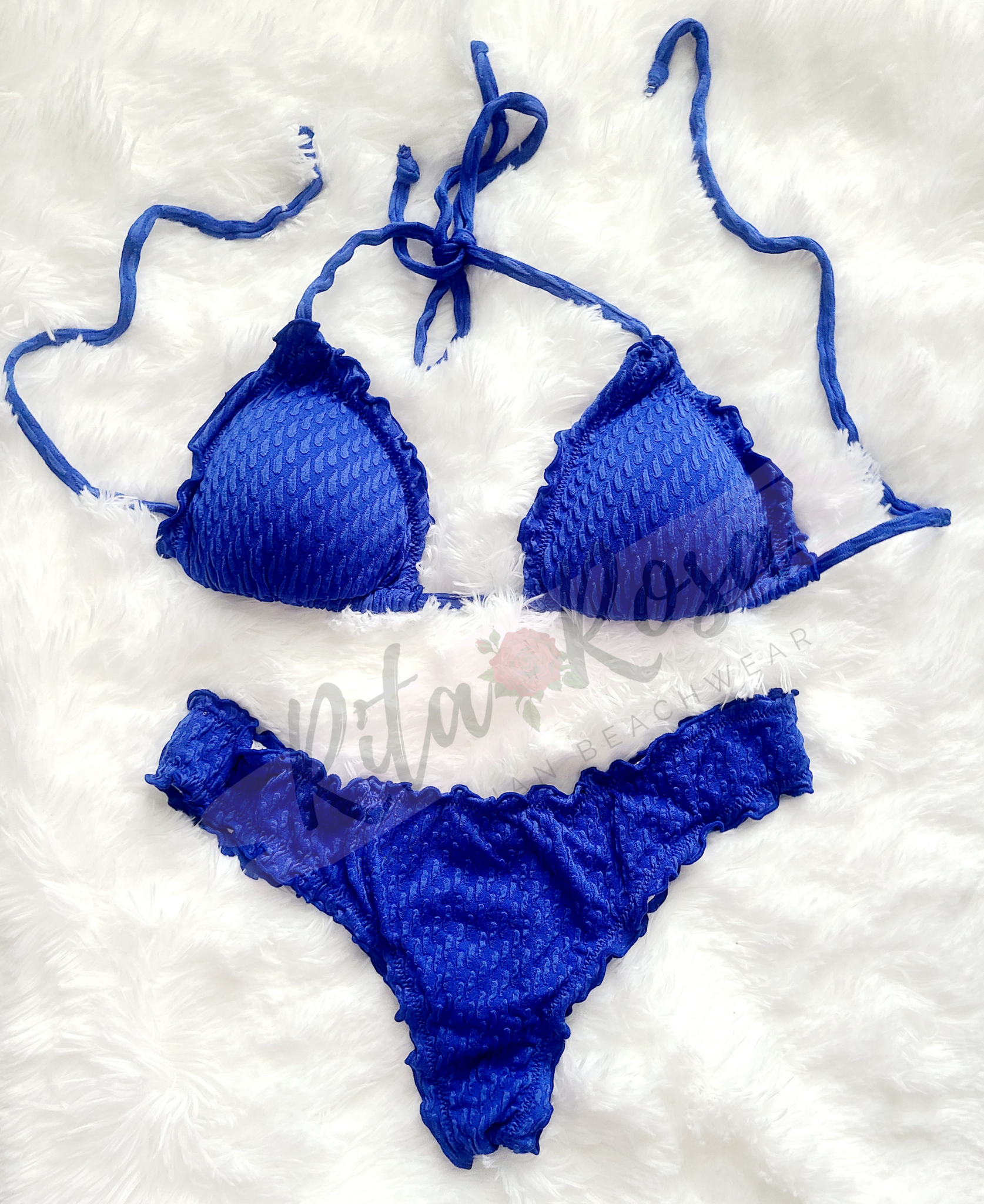 A woman wearing a ruffled bikini top with tie straps and removable pads, paired with matching cheeky bottoms with a central seam on the back.